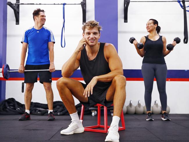 Matthew Armstrong, studio manager from F45 Bondi pictured with clients Paul Edgar (left) and Michelle Avery (right). Picture: Sam Ruttyn