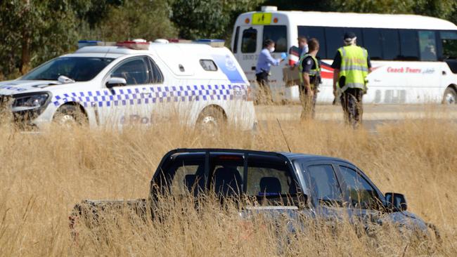 A car believed to have been used in the escape lies in grass near the Calder Highway. Picture: Daryl Pinder