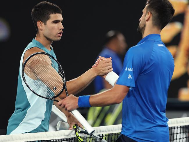 Spain's Carlos Alcaraz shakes hands with Serbia's Novak Djokovic after their men's singles quarterfinal match on day ten of the Australian Open tennis tournament in Melbourne on January 22, 2025. (Photo by Martin KEEP / AFP) / -- IMAGE RESTRICTED TO EDITORIAL USE - STRICTLY NO COMMERCIAL USE --