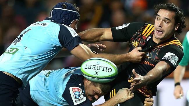 James Lowe of the Chiefs is tackled by Dean Mumm, left, and Tom Robertson of the Waratahs  during the Round 15 Super Rugby match between the Chiefs and Waratahs at Waikato Stadium in Hamilton, Saturday, June 3, 2017. (AAP Image/ David Rowland) NO ARCHIVING, EDITORIAL USE ONLY