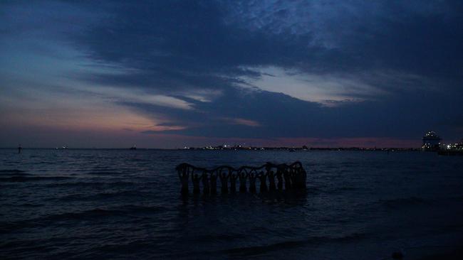 Players wade through the water at St Kilda Beach holding “Kevin” overhead. Photo: Darcy Parkinson