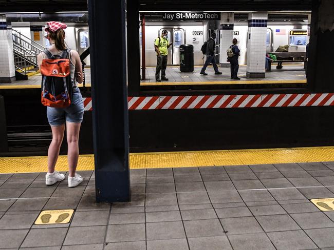 People wait for the subway on the new social distancing reminders in Brooklyn. Picture: AFP