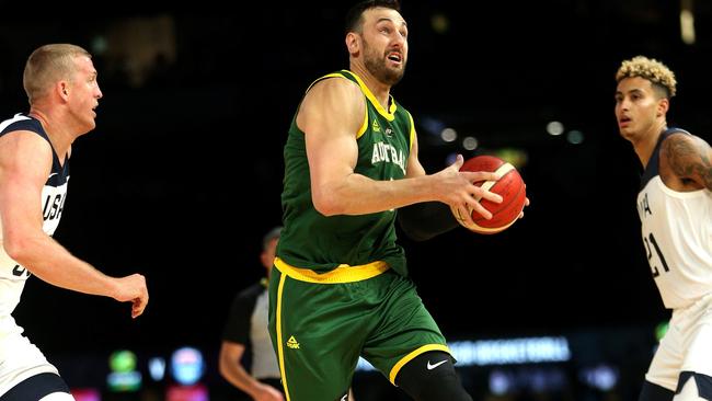 Andrew Bogut drives past Mason Plumlee (left) and Kyle Kuzma of the USA. Picture: AAP