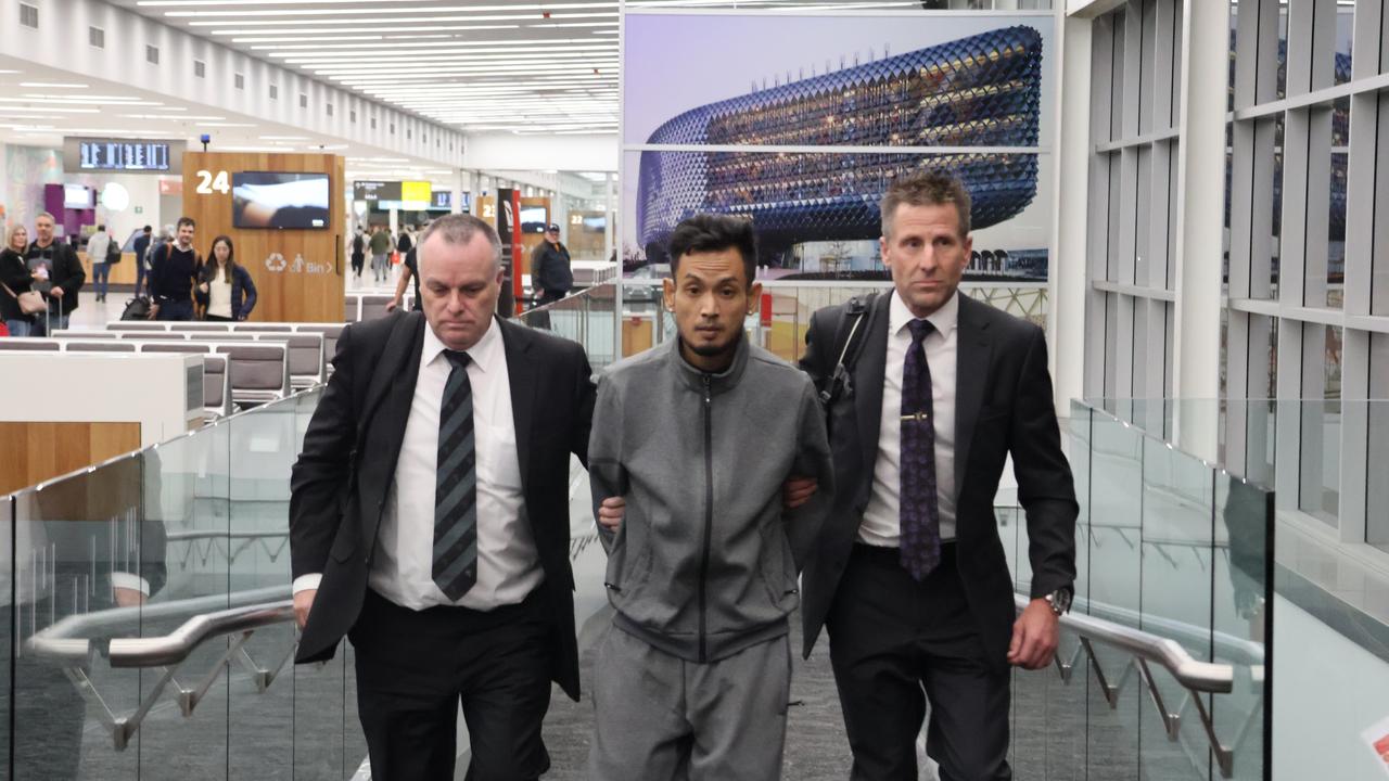 Detectives lead Kim Long Rim through Adelaide Airport after he was extradited from Melbourne on Saturday over the 2007 murder of Thea Kheav. Picture: Riley Walter