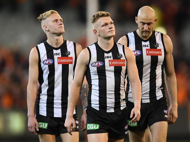 Jaidyn Stephenson, Adam Treloar and Ben Reid of the Magpies look dejected after losing the AFL Preliminary Final match between the Collingwood Magpies and the Greater Western Sydney Giants at the Melbourne Cricket Ground on September 21, 2019 in Melbourne, Australia. (Photo by Quinn Rooney/Getty Images)