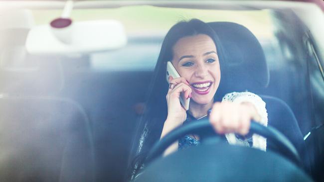 Careless young woman talking on her mobile phone while driving