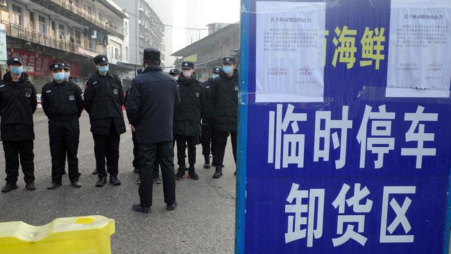 Security guards standing in front of the closed Huanan wholesale seafood market. Picture: AFP.