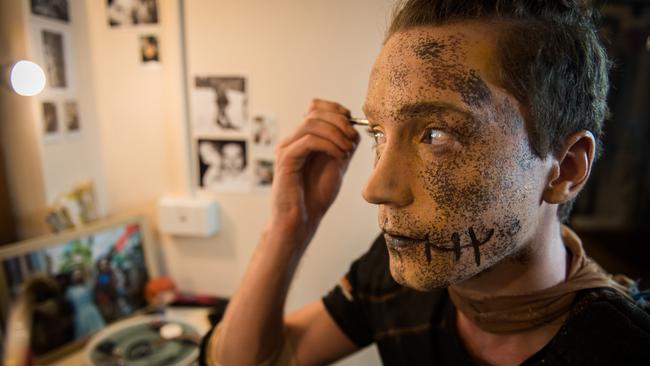 Scarecrow, played by Eli Cooper meticulously applies his makeup. Picture: Tom Huntley