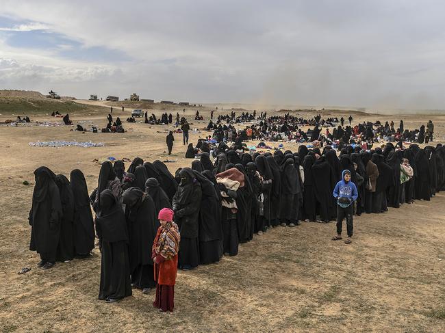 Civilians evacuated from the Islamic State (IS) group's embattled holdout of Baghouz wait at a screening area held by the US-backed Kurdish-led Syrian Democratic Forces (SDF), in the eastern Syrian province of Deir Ezzor, on March 5, 2019. - Kurdish-led forces launched a final assault Friday on the last pocket held by the Islamic State group in eastern Syria, their spokesman said. The "operation to clear the last remaining pocket of ISIS has just started", Mustefa Bali, the spokesman of the US-backed Syrian Democratic Forces, said in a statement using an acronym for the jihadist group. (Photo by Bulent KILIC / AFP)