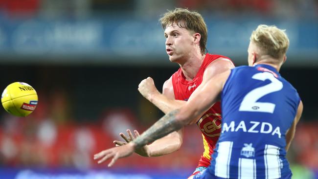 GOLD COAST, AUSTRALIA - MARCH 27: Noah Anderson of the Suns handballs during the round 2 AFL match between the Gold Coast Suns and the North Melbourne Kangaroos at Metricon Stadium on March 27, 2021 in Gold Coast, Australia. (Photo by Chris Hyde/Getty Images)