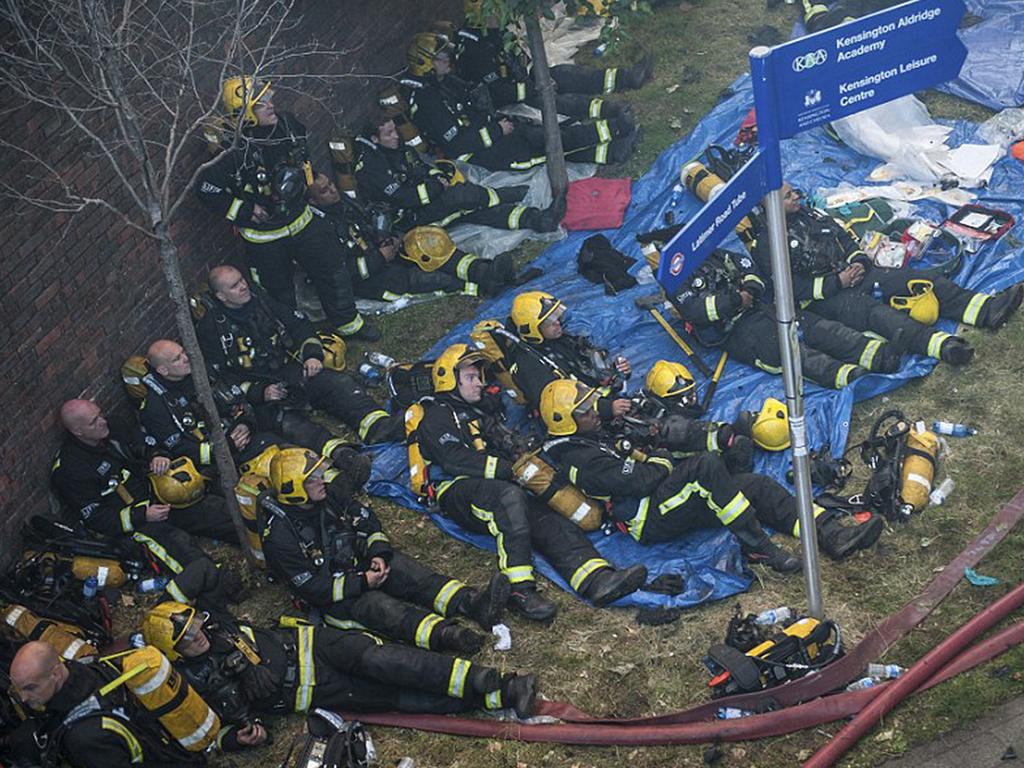 Firefighters resting in the morning after hours spent fighting the fire in Grenfell Tower. Picture: Guilhem Baker/LNP