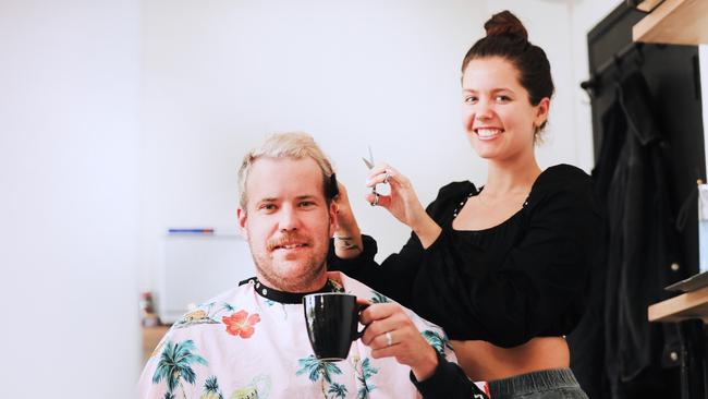 Tugun Barber Britt Westcott attends to a hair cut on customer Jordan Symes while he enjoys a coffee at Made. Photo: Scott Powick.