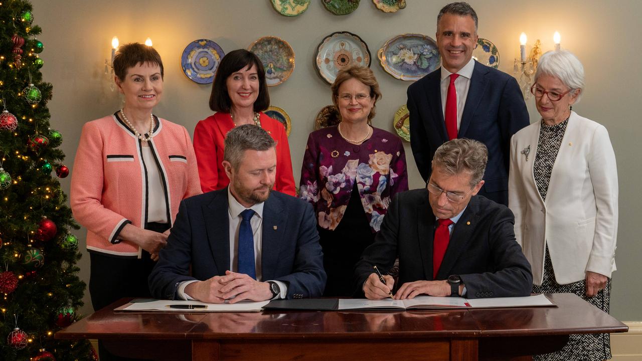 A university merger agreement is inked at Government House on December 6, 2022. (L-R) UniSA chancellor Pauline Carr, Deputy Premier Susan Close, Governor Frances Adamson, Premier Peter Malinauskas, University of Adelaide chancellor Catherine Branson (l-r front) UniSA vice-chancellor David Lloyd and University of Adelaide vice-chancellor Peter Hoj. Picture: Naomi Jellicoe