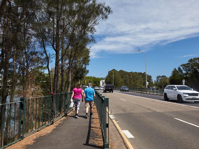 People walk across the Narrabeen bridge.