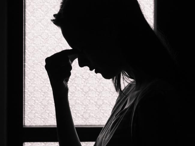 Depressed young woman in a dark room