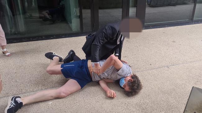 A man is arrested during Premier Steven Marshall's daily Covid press conference. Picture: Andrew Hough