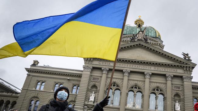 A man waves a Ukrainian flag in front of the Swiss House of Parliament in Bern during a national demonstration against the war in Ukraine at the weekend. Picture: AFP