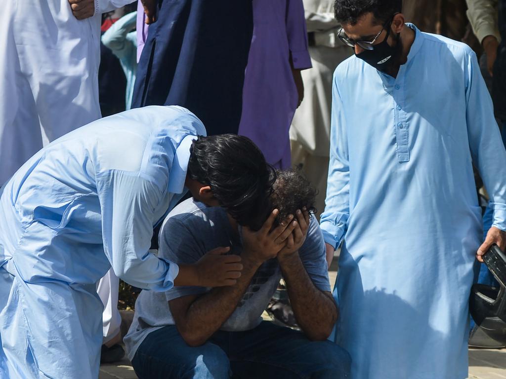 People comfort a relative of a victim near the site after a Pakistan International Airlines aircraft crashed in a residential area in Karachi. Picture: AFP