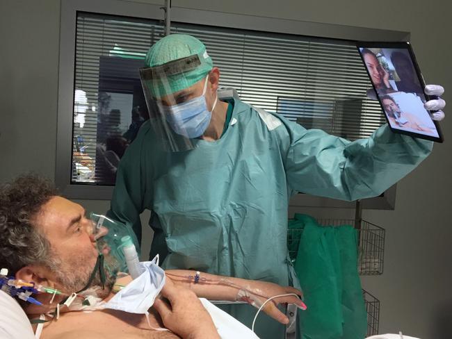 Doctor Matteo Flippini holds a tablet so patient Alessandro Mattinzoli to talk to his relatives via video conference in the ICU room of the Spedali Civili hospital in Brescia, northern Italy. Picture: AP