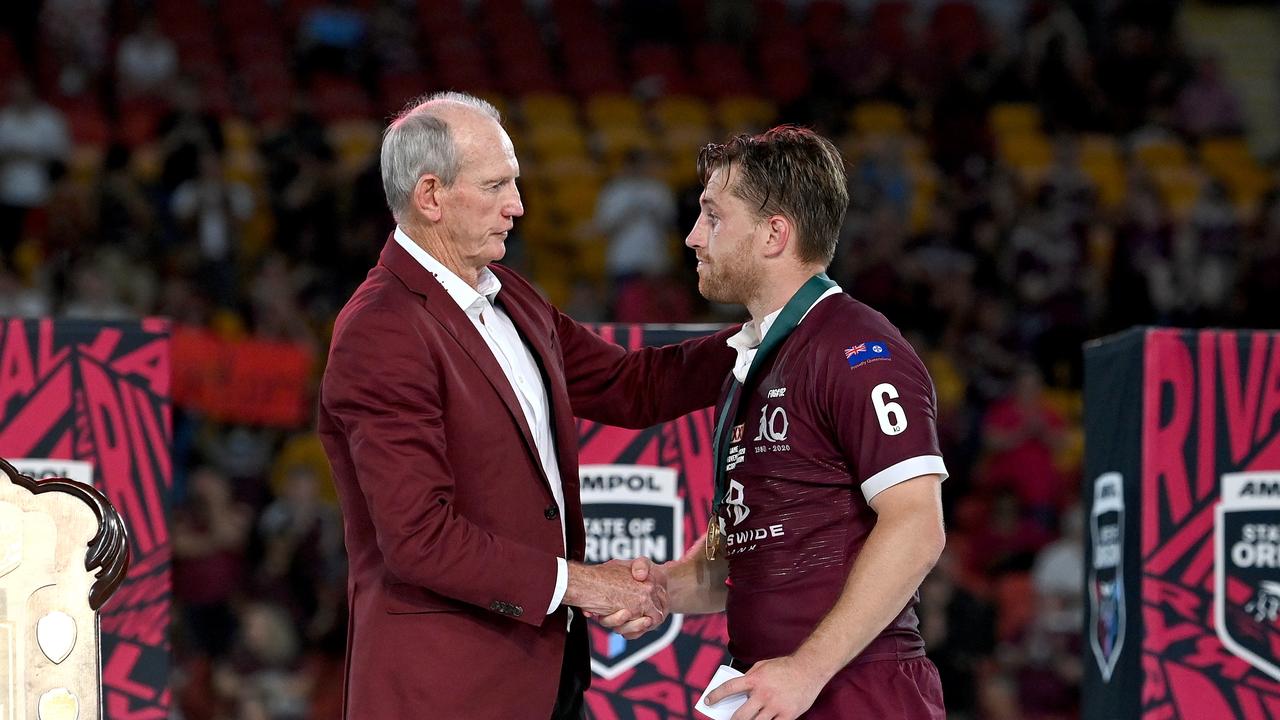Cameron Munster is presented with the man of the match award by Maroons coach Wayne Bennett