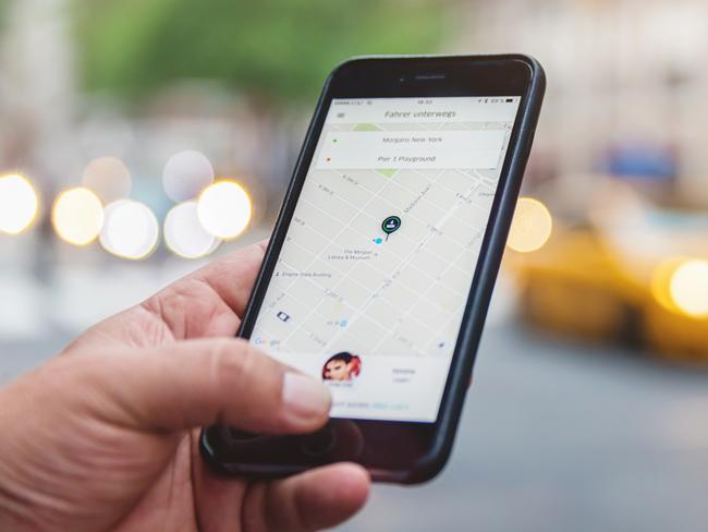 Man using the Uber App.Picture: iStockUber for travellers, Escape, Tim Richards