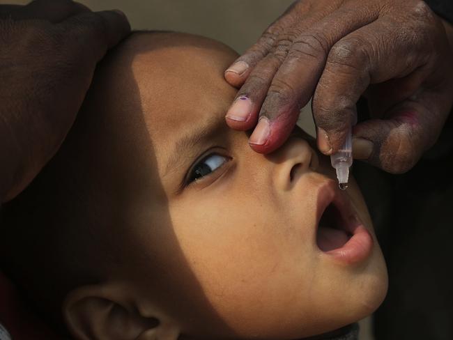 FILE - In this Dec. 11, 2018 file photo, a Pakistani health worker gives a polio vaccination to a child in Karachi, Pakistan. Pakistani officials said, Wednesday, Jan. 9, 2019 that the country is on track to eradicate polio in 2019 despite Taliban attacks and superstition that has spurred many parents in the region bordering Afghanistan to refuse to vaccinate their children against the crippling disease. (AP Photo/Shakil Adil, File)