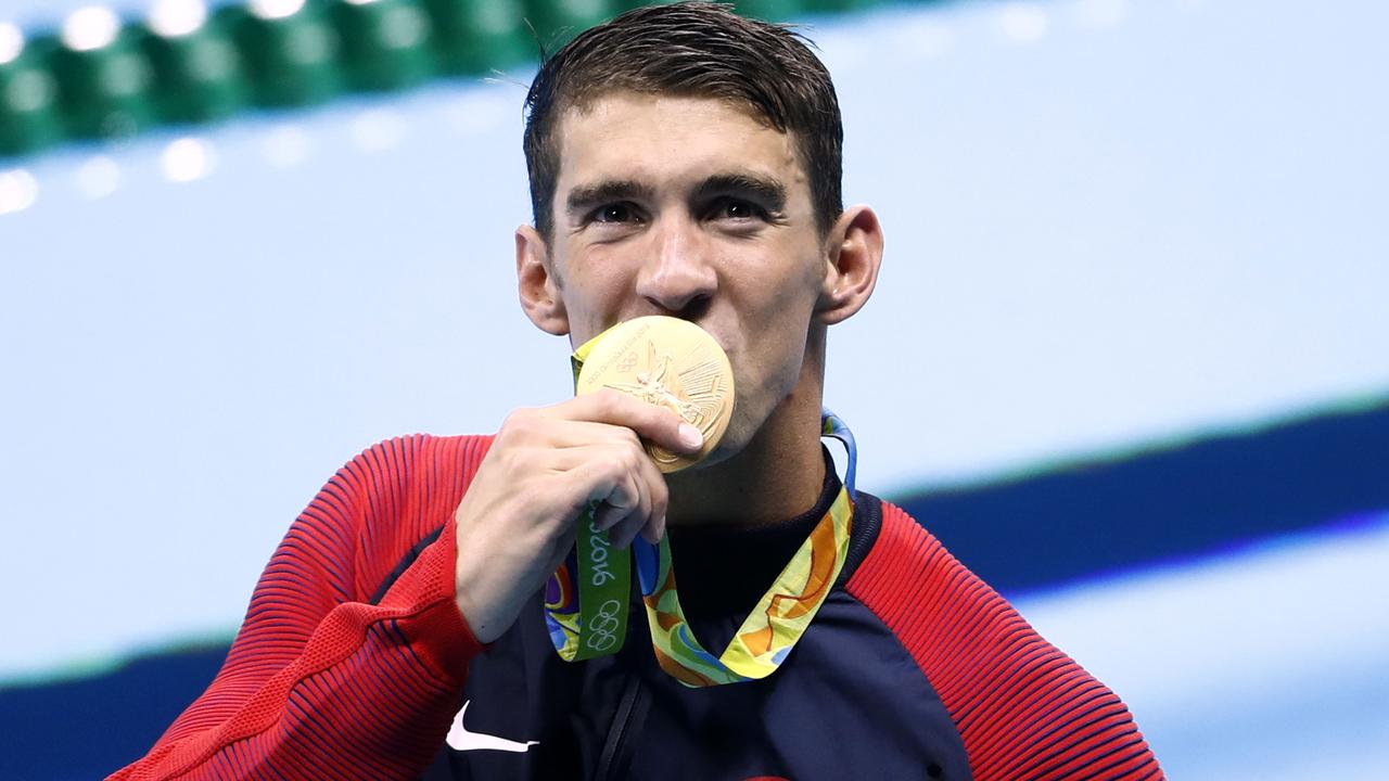 US swimmer Michael Phelps kisses one of his 23 Olympic gold medals that have made him the most successful Olympian in history. Picture: AFP