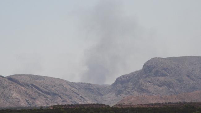 Haze engulfed the West MacDonnell Ranges on Saturday afternoon when viewed from Larapinta Dr, with large smoke plumes on the side of them. Picture: Gera Kazakov