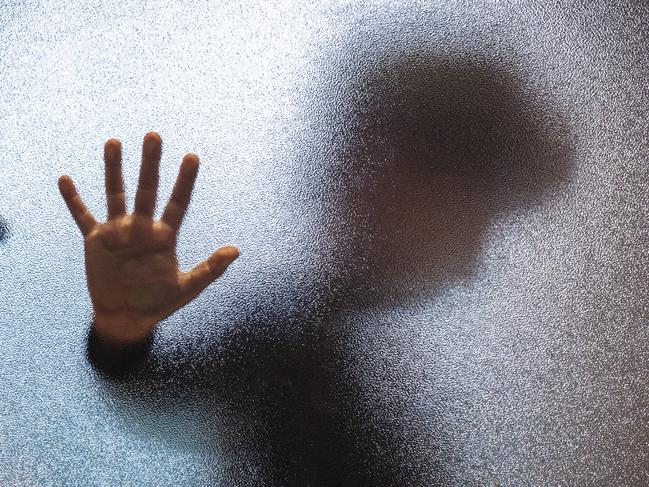 Blurred sad boy leaning open hand against glass door. TSS (The Southport School) stock photo. Photo: iStock