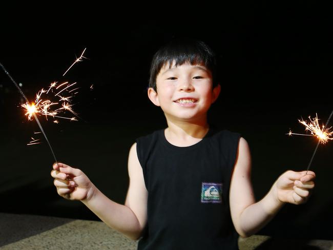 Noah Miln, 6, lights some sparklers on New Year's Eve on the Cairns Esplanade. Picture: Brendan Radke