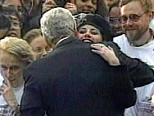 Intern Monica Lewinsky embraces US President Bill Clinton during White House lawn party in Washington, 1996.