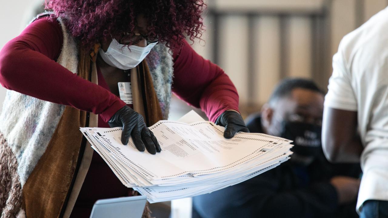 A Fulton County worker moves a stack of absentee ballots at State Farm Arena on November 6 in Atlanta, Georgia. Picture: Jessica McGowan/Getty Images/AFP