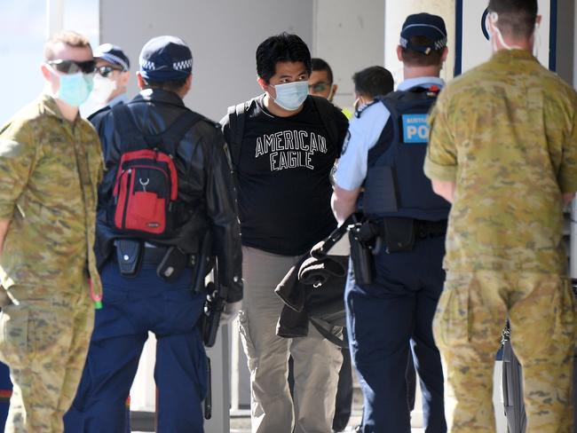 Crew from the Ruby Princess cruise ship are seen arriving at Sydney International Airport in Sydney, Thursday, April 23, 2020. The Ruby Princess cruise ship has been told to leave Australia by Thursday, as an inquiry begins. (AAP Image/Dan Himbrechts) NO ARCHIVING