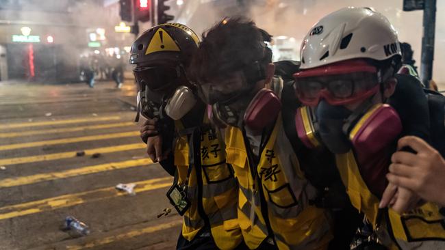 Volunteer medics help a protesters hit by teargas in Hong Kong’s Wan Chai district on Saturday. Picture: Getty Images