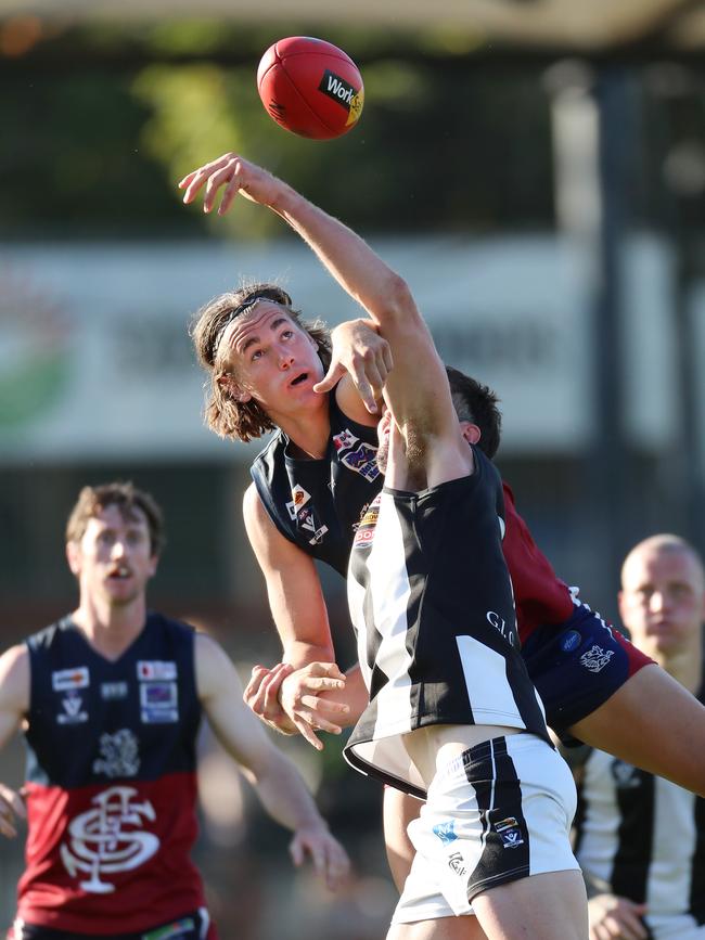 Sandhurst’s Seb Collins rises above Castlemaine coach Michael Hartley.