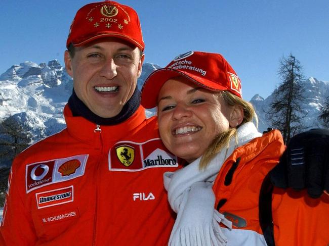 (FILES) Formula one World champion Ferrrari driver Michael Schumacher (L) poses in Madonna di Campiglio with his wife Corinna  16 January 2003. Two men accused of trying to blackmail relatives of Formula One legend Michael Schumacher had access to private family photos, German prosecutors said on July 3, 2024. Data records combed by investigators included "photo files relating to the Schumacher family's private life", the prosecutors in the western city of Wuppertal said in a statement. German authorities announced in June 2024 they had arrested a father and son on suspicion of trying to blackmail the Schumacher family. (Photo by Ercole COLOMBO / POOL / AFP)