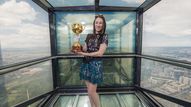 Jockey Katelyn Mallyon with the 2016 Emirates Melbourne Cup at Eureka Sky Deck's The Edge. Picture: Jason Edwards