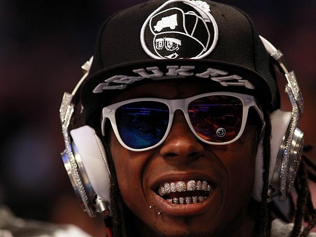 Lil' Wayne, wearing diamond studded beats headphones by Dr. Dre sits courtside during the 2012 NBA All-Star Game in February 2012. 