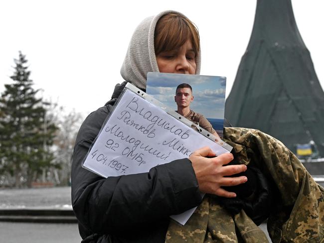 A woman holds the portrait and the military uniform of her fallen son during the commemoration event of fallen Ukrainian soldiers in the centre of Kharkiv. Picture: AFP