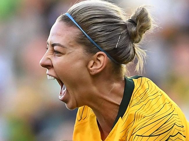 Australia's Alanna Kennedy (C) leaps into the arms of teammate Sam Kerr (L) after scoring against Argentina's during their Women's Cup of Nations football match in Melbourne on March 6, 2019. (Photo by WILLIAM WEST / AFP) / -- IMAGE RESTRICTED TO EDITORIAL USE - STRICTLY NO COMMERCIAL USE --