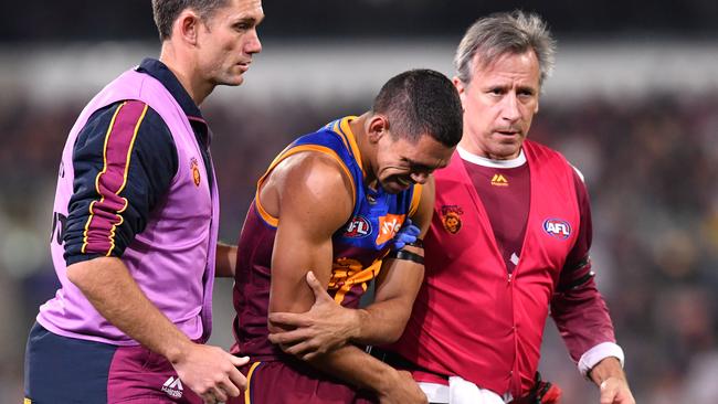 Charlie Cameron of the Lions leaves the field in pain.