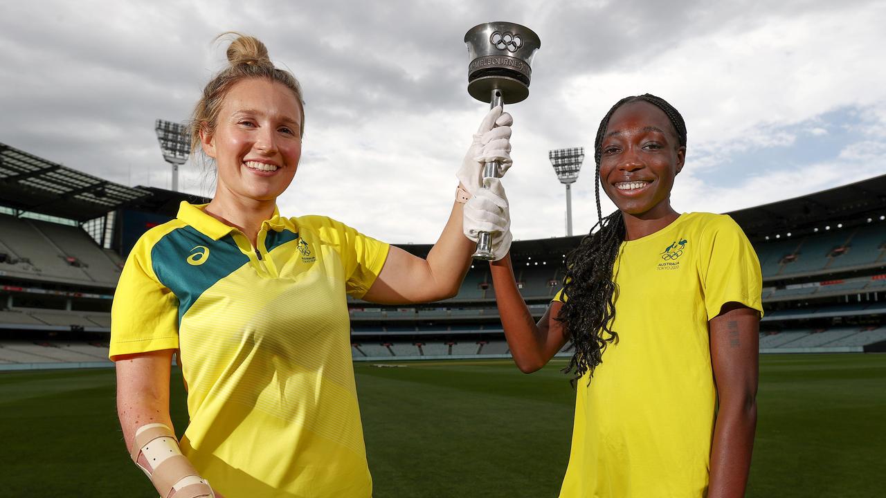 Current Olympians Milly Tapper and Bendere Oboya with the 1956 Olympic Torch.