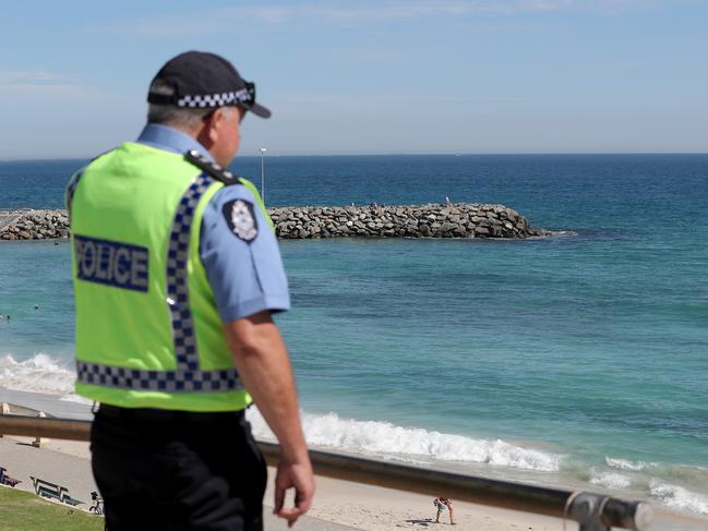 Police officers are seen patrolling Cottesloe Beach in Perth on Friday, April 10, 2020. Beaches remain open but the Western Australian government have warned the public they could be closed if people do not adhere to social distancing rules. (AAP Image/Richard Wainwright) NO ARCHIVING