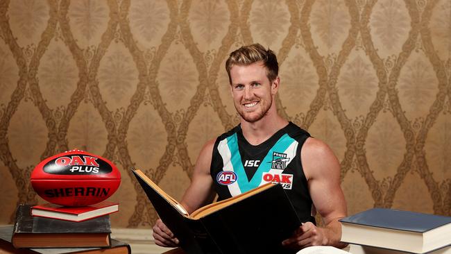 Port Adelaide defender Tom Jonas just completed his law degree after achieving an ATAR of 97 at Rostrevor College. He is pictured with law books at the school. Picture: DYLAN COKER