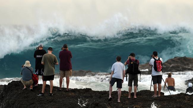 Photographers are seen at Snapper Rocks on the Gold Coast, Thursday February 21, 2019. Huge swells and high tides are set to pummelling southeast Queensland beaches over the coming days as Cyclone Oma tracks towards the Queensland coast. (AAP Image/Dave Hunt)