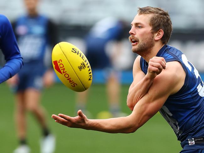 Tom Atkins fires a handball at training