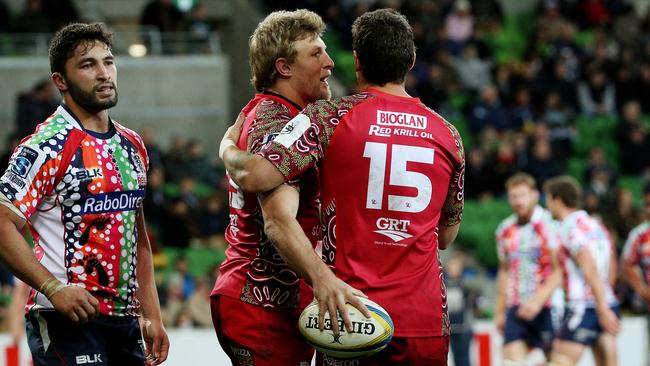 Super Rugby - Melbourne Rebels v Queensland Reds at AAMI Park, Lachie Turner celebrates a try with Mike Harris as Colby Faingaa looks on. June 27th 2014. Picture : Colleen Petch