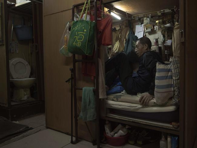 Wong Tat-ming, 63, sits in his ‘coffin home’ which is next to a set of grimy toilets in Hong Kong as he pays $420 a month for a compartment measuring three feet by six feet. It's crammed with all his meagre possessions, including a sleeping bag, small colour TV and electric fan. Picture: Kin Cheung/AP