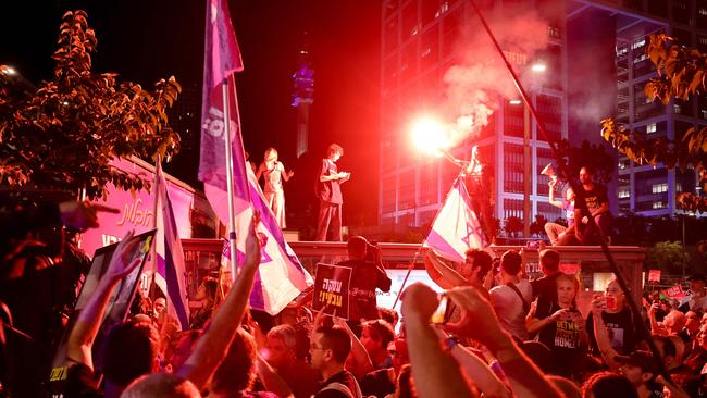 Israeli anti-government demonstrators hold placards and wave national flags during a protest calling for action to secure the release of Israeli hostages held captive since the October 7 attacks by Palestinian militants in the Gaza Strip, in front of the Israeli Defence Ministry in Tel Aviv. Picture: AFP