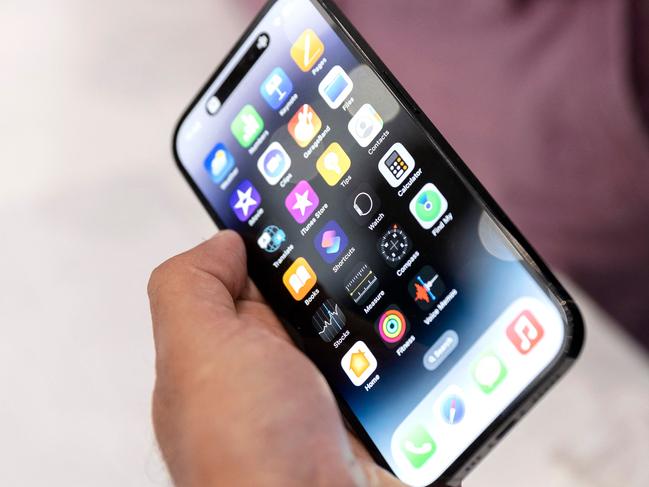 An Apple associate holds one of the new iPhone Pros during a launch event for new products at Apple headquarters in Cupertino, California, on September 7, 2022. - Apple unveiled several new products including a new iPhone 14 and 14 Pro, three Apple watches, and new AirPod Pros during the event. (Photo by Brittany Hosea-Small / AFP)